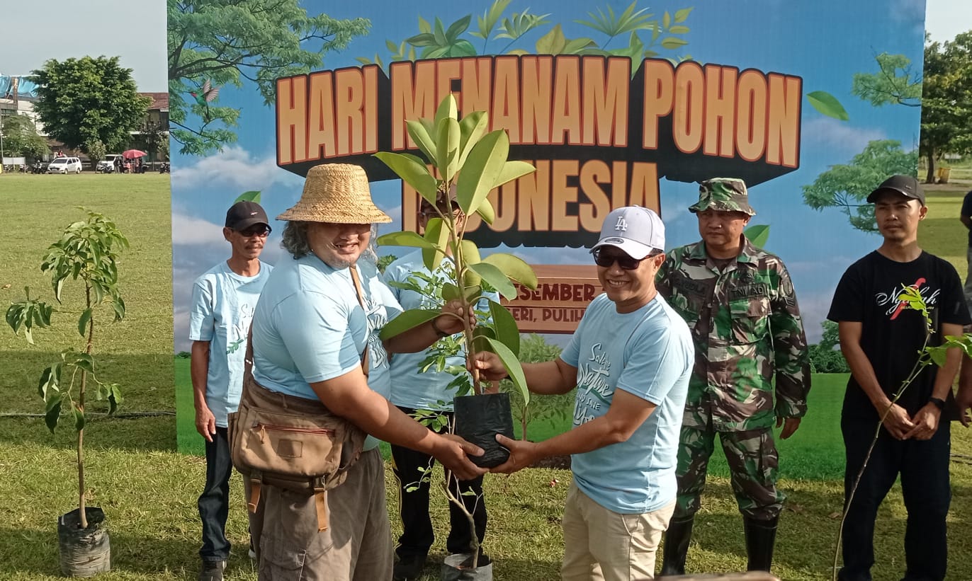 Koordinator ARPL Kediri, Ari Purnomo Adi saat menyerahkan bibit  pohon secara simbolis kepada Kepala DLH Kabupaten Kediri Putut Agung Subekti. Foto: Muji Harjita/BANGSAONLINE