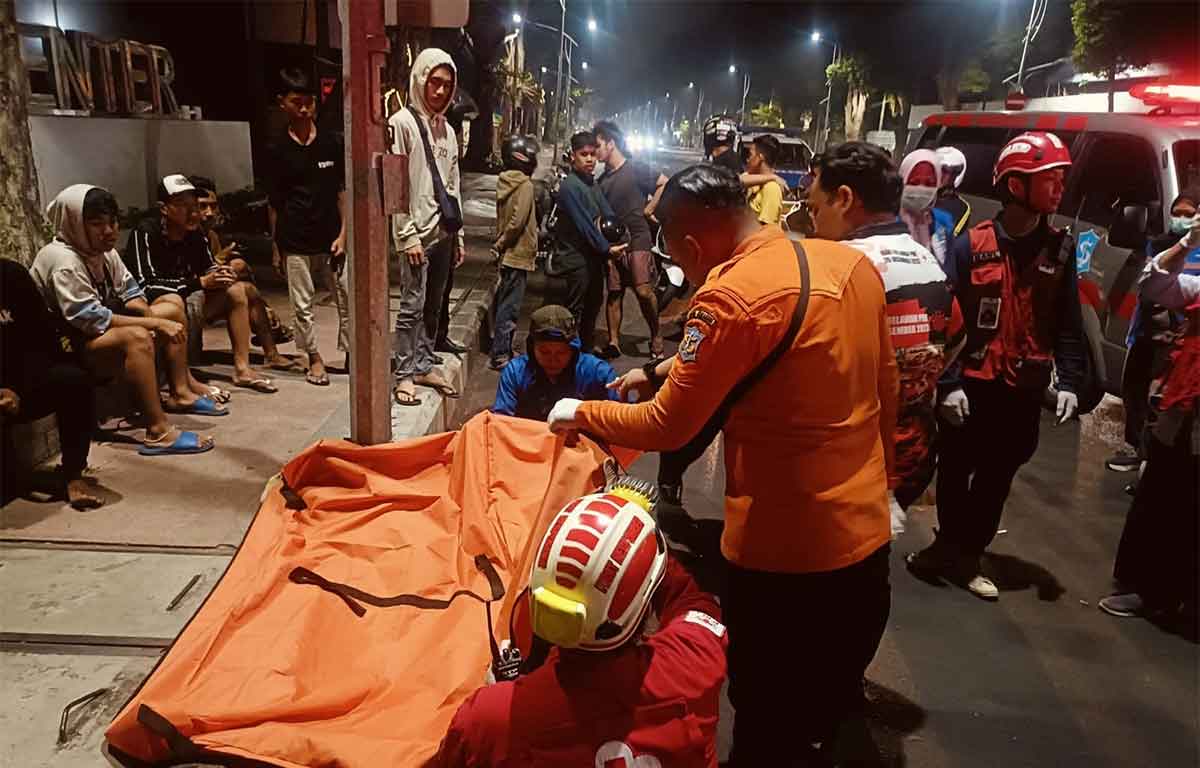Petugas saat mengevakuasi korban kecelakaan tunggal di Jalan Panglima Sudirman, Surabaya.