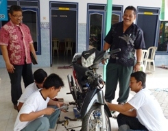  Subakti, Instruktur pelatihan (kiri) dan Kepala Desa Panggreh HM Zainul (kanan), melihat peserta sedang memperbaiki sepeda motor. foto: agus/BangsaOnline
