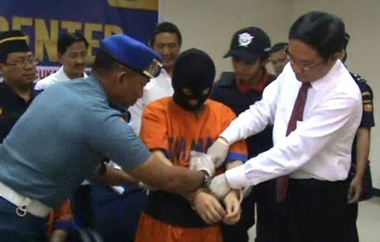 PRAKTIK – Tersangka Wu Chi Lung menunjukkan cara menyembunyikan sabu di badannya, saat di Kantor Kanwil Bea dan Cukai Jatim I, Jalan Raya Juanda, Sidoarjo, Kamis (30/10/2014). foto: nanang ichwan/BangsaOnline