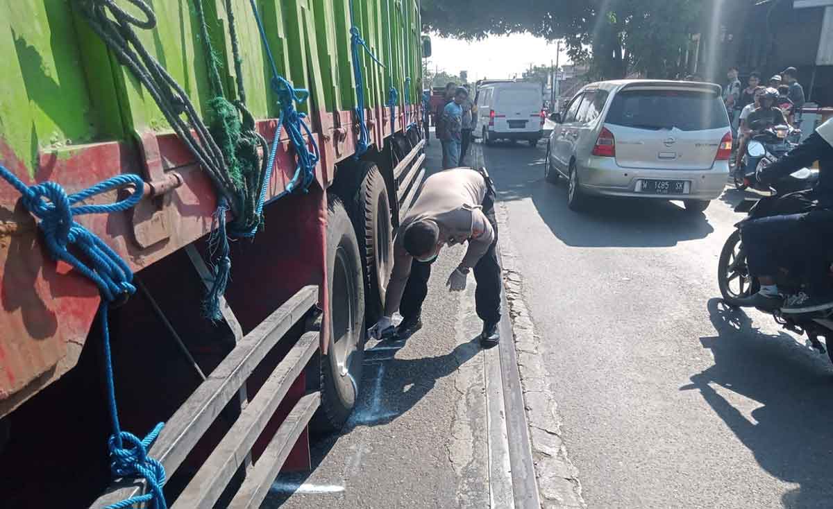 Petugas Satlantas Polres Jombang saat mengevakuasi korban kecelakaan.