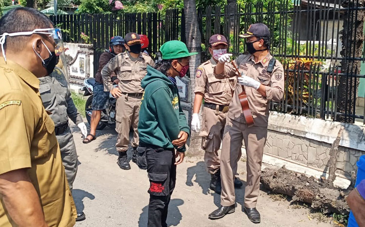 Seorang pengamen apes saat kena razia petugas gabungan. (foto: ist.)
