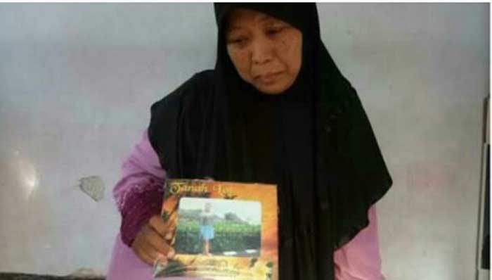 Ibu korban menunjukkan foto anaknya yang menjadi korban gempa di Lombok.