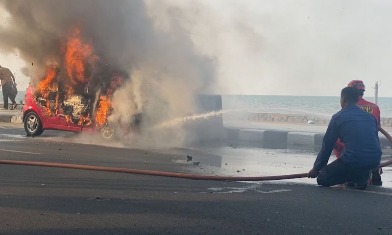 Petugas Damkar Kabupaten Tuban saat berusaha memadamkan mobil yang terbakar