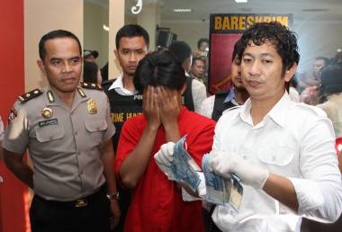 Tersangka diapit Kasat Reskrim AKBP Takdir Mattanete dan Kasubbag Humas Kompol Widjanarko. foto: rusmiyanto/BANGSAONLINE