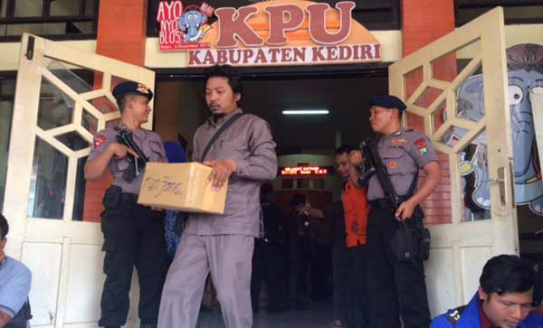etugas kepolisian saat mengawal pendistribusian surat suara dari kantor KPU ke masing-masing kantor PPK. foto: arif kurniawan/ BANGSAONLINE