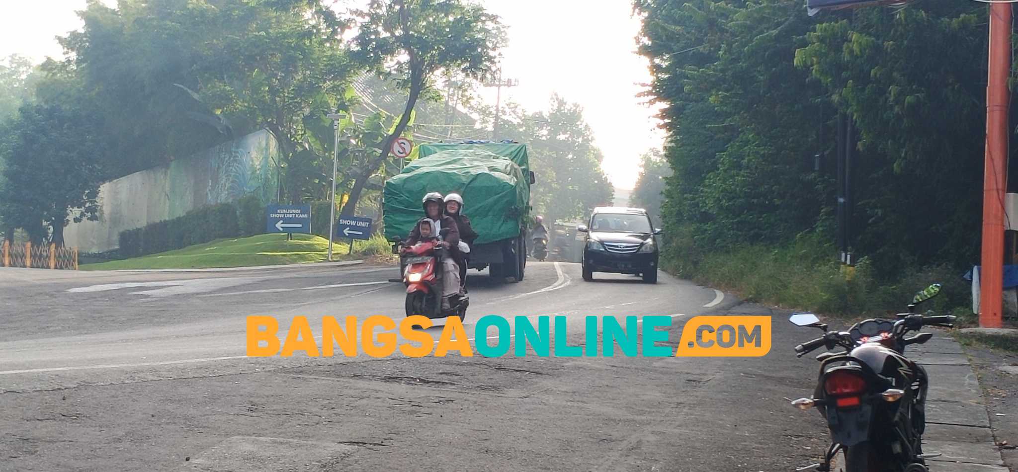 Kendaraan sarat muatan berhenti di tengah Jalan Mayjen Sungkono di sekitar Bukit Condrodipo, Desa Kembangan, karena tak kuat menanjak. Foto: SYUHUD/ BANGSAONLINE
