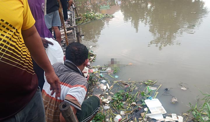 Warga menunjukkan mayat bayi yang ditemukan di Sungai Sukodono, Sidoarjo.