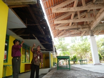 Kepala Desa KrembungSupandi (kanan) dan Fatkhul Khorib, Pjs Sekretaris Desa Krembung menunjukkan kerusakan. Foto: agus HP/BANGSAONLINE
