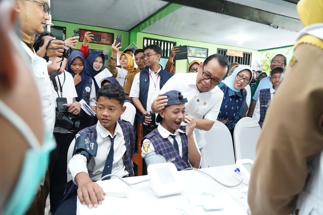 Menko PMK, Pratikno saat berinteraksi dengan salah satu siswa SMP Negeri 1 Padangan Bojonegoro yang mengikuti cek kesehatan gratis