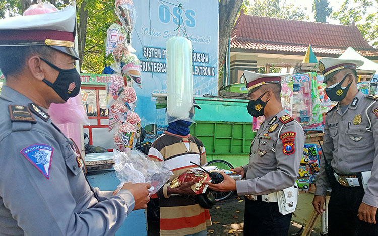 Satlantas Polres Probolinggo Kota memberikan bantuan berupa beras dan masker gratis. (foto: ist)