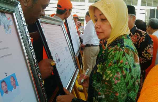 Calon Bupati Kediri Haryanti Sutrisno saat menandatangani deklarasi damai di halaman kantor KPUD Kabupaten Kediri. (arif kurniawan/BANGSAONLINE)