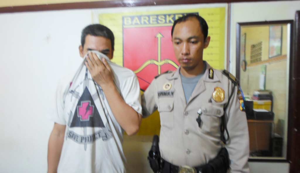Tersangka Lusiando didampingi petugas Polsek Waru. foto: catur andy/ BANGSAONLINE
