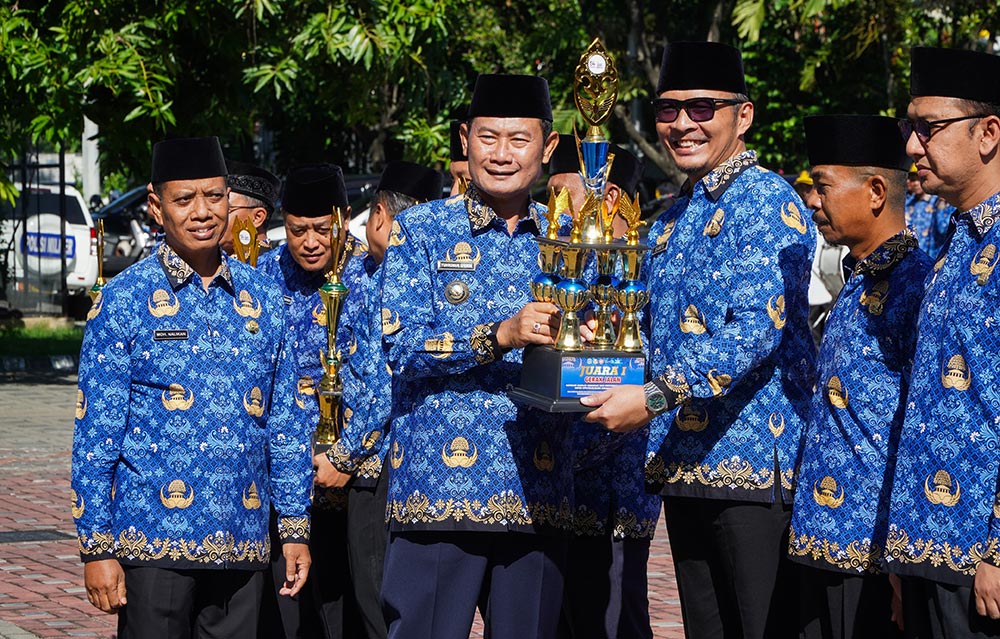 Bupati Lamongan Yuhronur Efendi saat memberikan penghargaan kepada ASN berprestasi di sela apel Hari Anti Korupsi Sedunia tahun 2025.