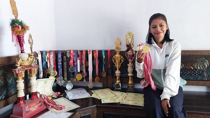 Mila Karmila (21), Atlet Kota Probolinggo bersama sejumlah piala, medali, hingga piagam penghargaan yang berhasil ia koleksi berkat prestasinya di bidang olah raga.