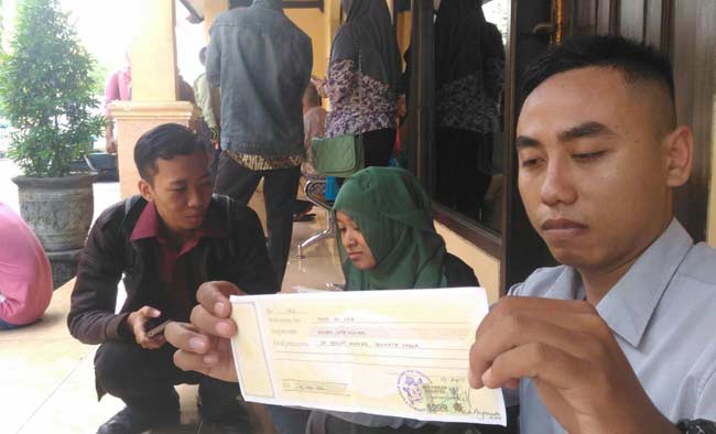 Salah satu korban menunjukkan bukti kwitansi yang diberikan tersangka.
foto: romza/ BANGSAONLINE