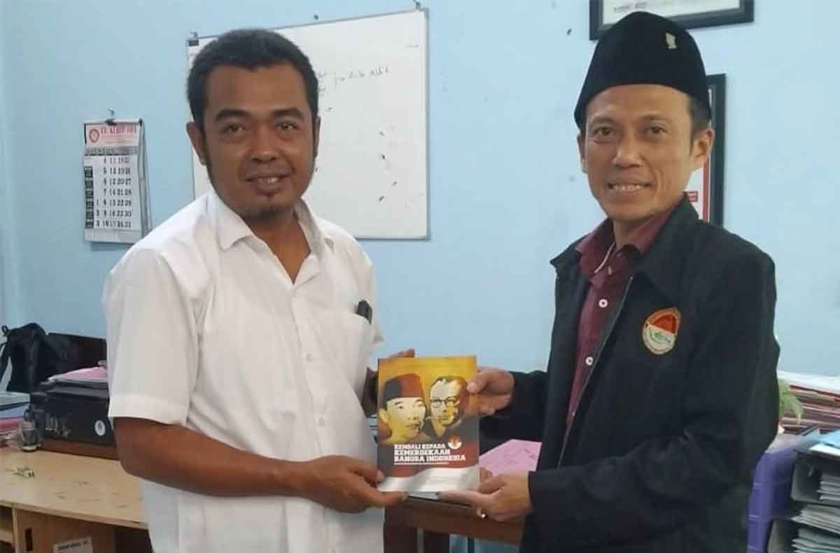 Ketua Harian Situs Ndalem Pojok Persada Soekarno Kediri, Kushartono (kanan), saat menyerahkan Buku 17 Agustus 1945 Negara Belum Ada. Foto: Ist