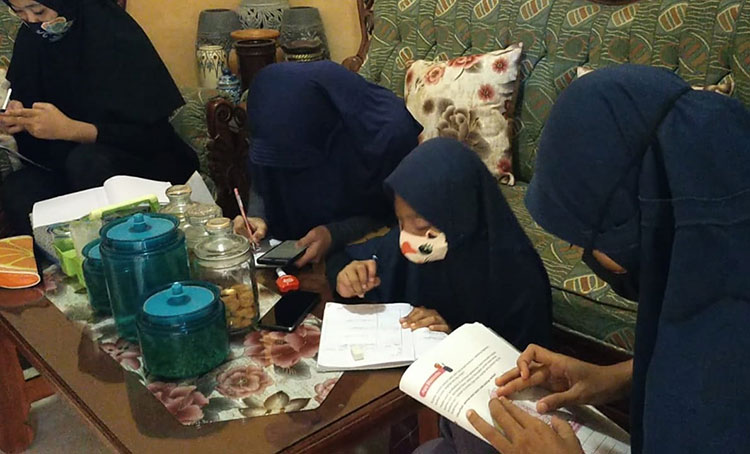 Para siswa saat belajar di rumah Tiwi memanfaatkan wifi gratis yang disediakan.  (foto: ist).