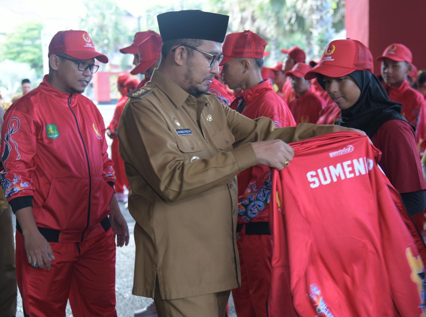 Bupati Sumenep, Achmad Fauzi Wongsojudo saat memasangkan jaket kepada atlet secara simbolis pada acara pelepasan Kontingen Sumenep Porprov Jatim ke-IX