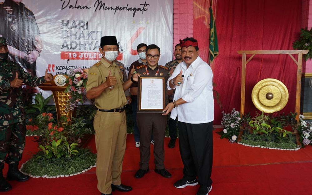 Plt Bupati Nganjuk Marhaen Djumadi (kanan) dan Kepala Kejari Nganjuk Nophy Tennophero Suoth (tengah) saat memberikan paket sembako secara simbolis kepada salah satu warga Desa Dawuhan.
