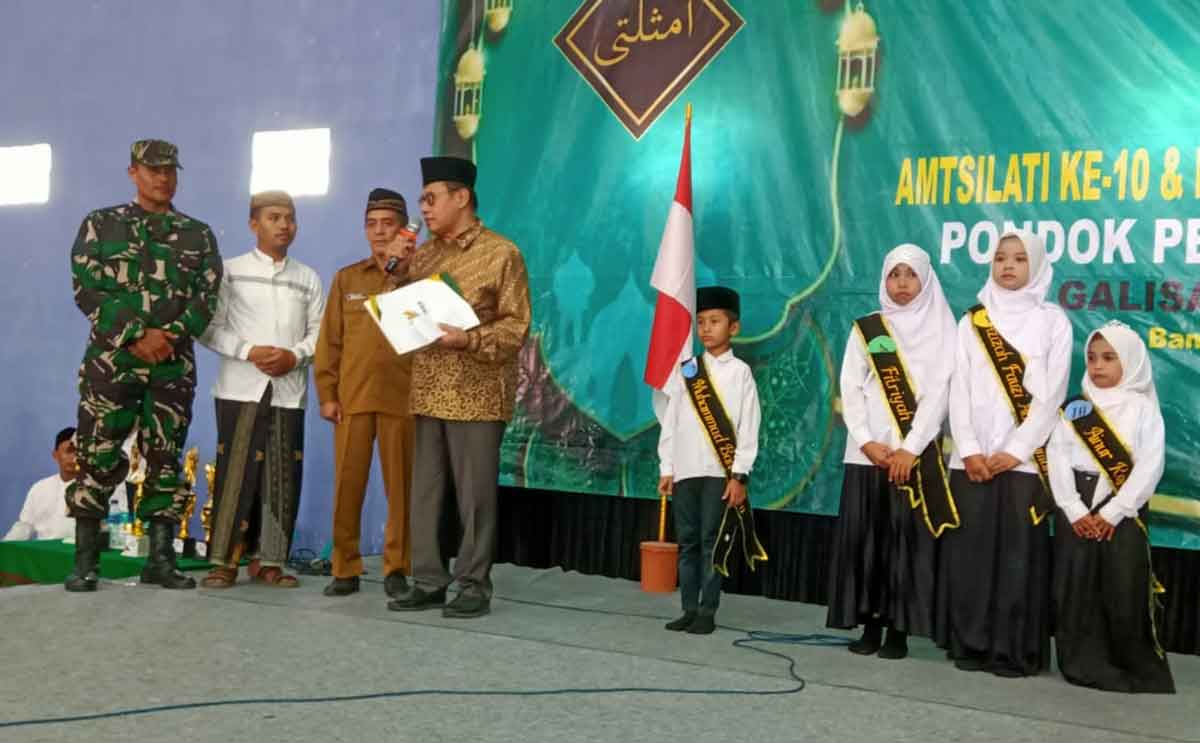 Wakil Ketua IV Baznas Jatim, KH Husnul Khuluq, saat memberikan beasiswa secara simbolis kepada salah satu siswa/santri berprestasi. Foto: Ist