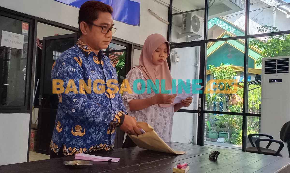 Plt Sekdes Roomo, Achmad Zainul (kiri), saat mengecek tagihan PBB sebelum didistribusikan kepada warga. Foto: SYUHUD/BANGSAONLINE