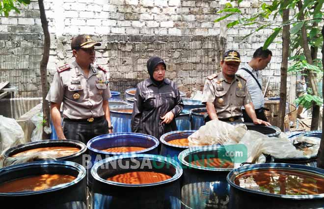 Kapolres Tuban menunjukkan ribuan liter baceman yang siap produksi. foto: GUNAWAN/ BANGSAONLINE