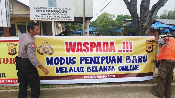 Petugas polisi memasang spanduk peringatan di depan Mapolsek Muara Satu Lhokseumawe, Aceh, Jumat (20/4/2017) agar masyarakat hati-hati, tidak tertipu belanja online. Karena Mapolsek Lhokseumawe  mengaku mendapat banyak sekali pengaduan dari masyarakat. Foto: ist