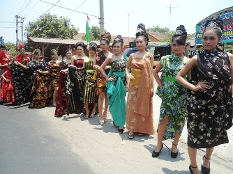 
Para model mengenakan batik saat beraksi di cat walk yang notabene berada di pinggir jalan. Foto: arif kurniawan/BANGSAONLINE
