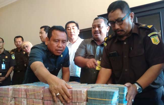 Kajari Sidoarjo HM. Sunarto SH (berpakaian safari) saat ikut menata uang pengembalian dugaan korupsi TKD Buduran dari Dirut PT. EPSS Cindro (berdiri baju putih). foto: nanang ichwan/ BANGSAONLINE