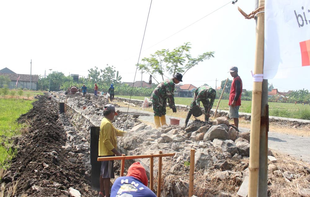 Satgas TMMD ke-126 bersama warga mengerjakan plengsengan irigasi. Foto: Ist.