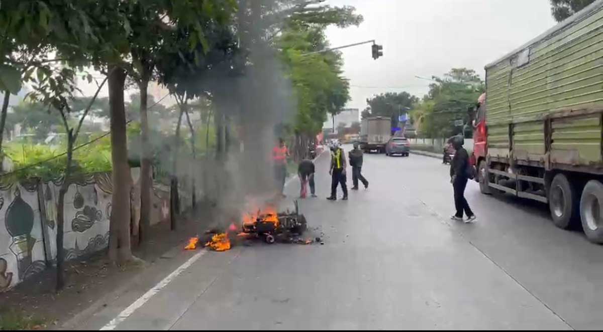 Petugas dari Satlantas Polres Gresik saat memadamkan motor yang terbakar di Terminal Bunder. Foto: Ist