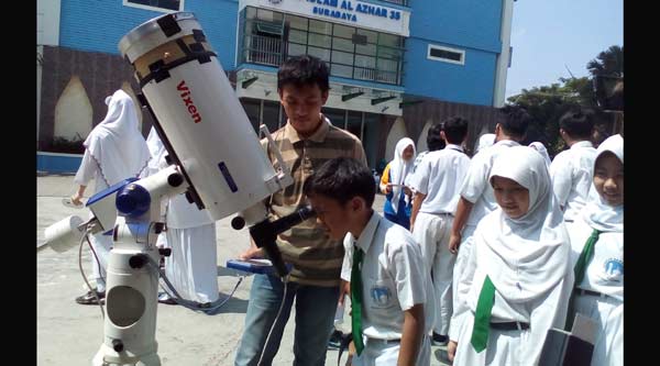 Sejumlah siswa SMP Al-Azhar 13 Surabaya melihat matahari menggunakan teleskop,  di halaman sekolah, Senin (7/3). foto: devi fitri/ BANGSAONLINE