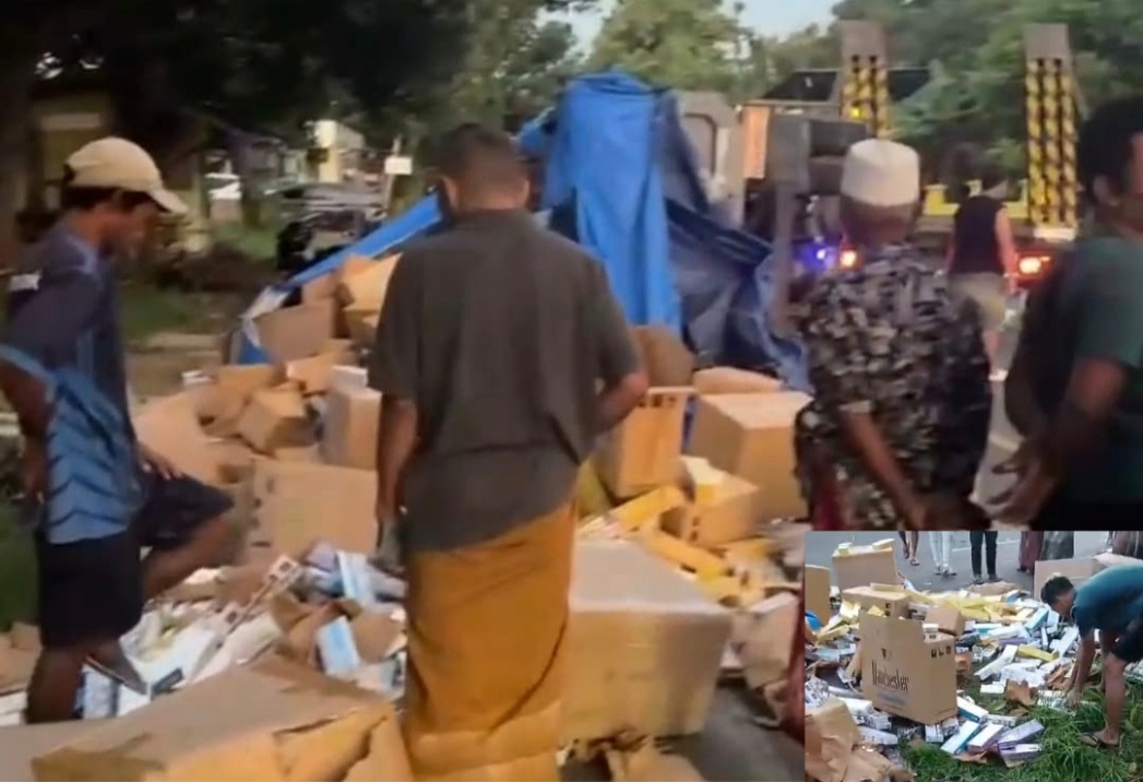 Tangkapan layar saat warga menyingkirkan muatan rokok yang tumpah ke tepian jalan