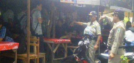 TERJARING – Sejumlah siswa terjaring razia Satpol PP karena cangkrukan di warung di kawasan Stadion Anjuk Ladang saat jam pelajaran, kemarin. foto: Soewandito/BANGSAONLINE