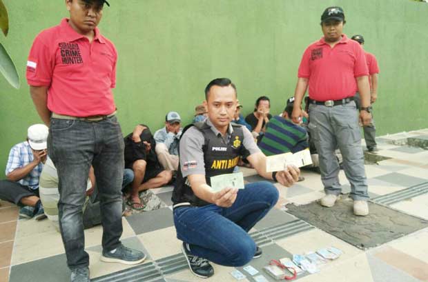 Wakasat Reskrim Polrestabes Surabaya saat menciduk jukir preman di Kebun Binatang beserta barang bukti Karcis dan sejumlah uang.
