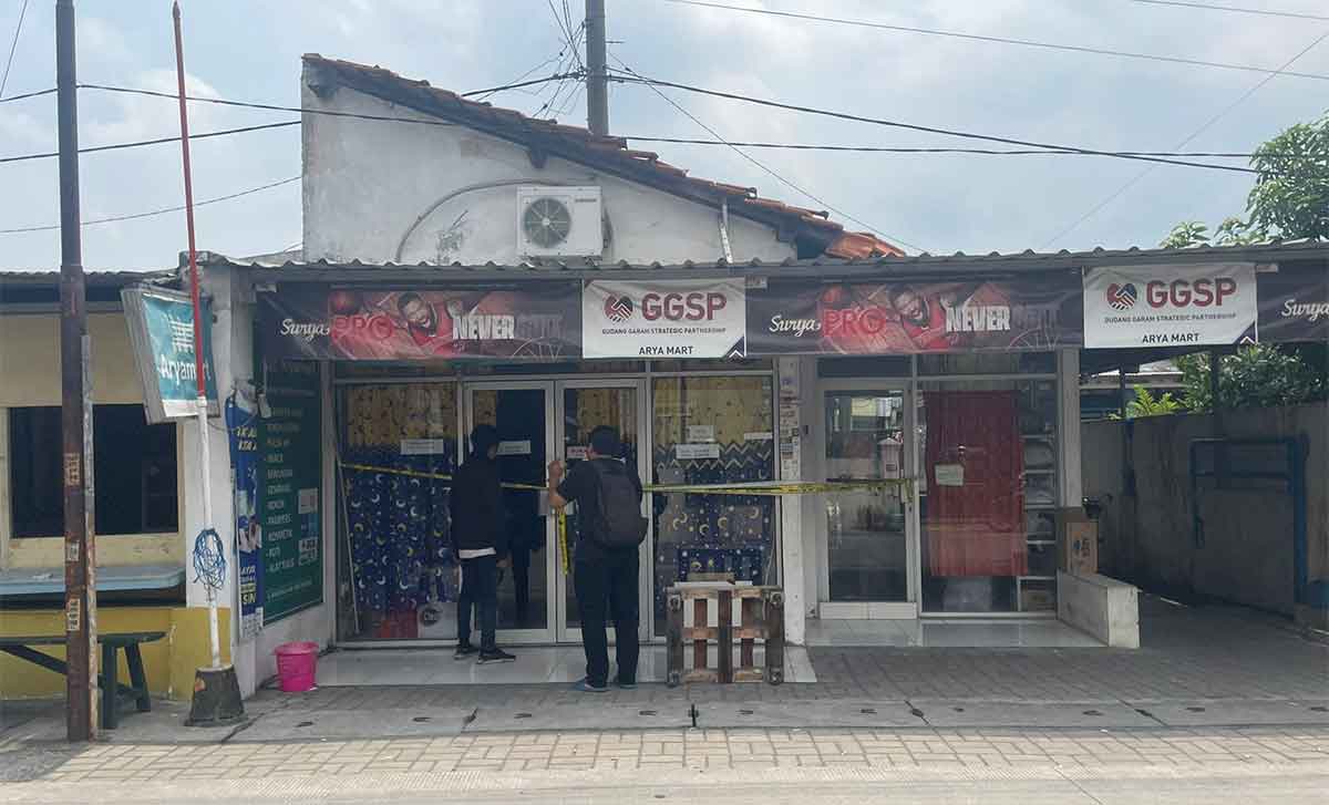 Petugas saat memasang garis polisi di TKP.