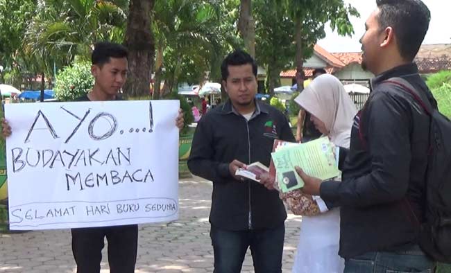 Pemuda di Sumenep saat mengajak pengunjung Taman Bunga baca buku. foto: rahmatullah/ BANGSAONLINE