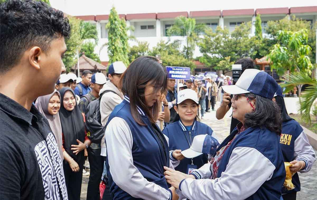 Pj Wali Kota Kediri, Zanariah, saat memakaikan jaket dan topi secara simbolis kepada perwakilan mahasiswa. Foto: Ist