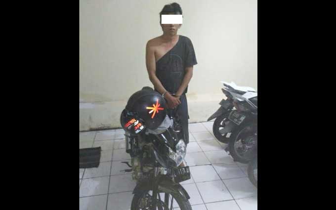 Pelaku bersama motor yang diamankan.