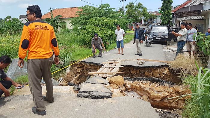 Petugas dibantu warga membuat jembatan sementara dari kayu untuk para pejalan kaki.