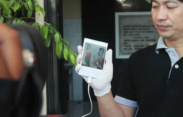 Kasatreskrim Polrestabes Surabaya, AKBP Takdir Matanette saat menunjukkan grup BBM untuk memajang foto-foto PSK. (foto: rusmiyanto/BANGSAONLINE)