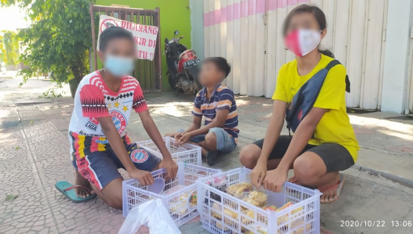 Tiga bocah ini tak kapok meski dua kali ditertibkan Satpol PP. Mereka tetap berjualan makanan pada para pengguna jalan di perempatan lampu merah, Lateng Banyuwangi. Uang yang mereka peroleh untuk membeli kuota internet belajar online dan sebagian diberikan kepada orang tuanya yang penghasilannya merosot akibat pandemi Covid-19. foto: teguh/ bangsaonline.com