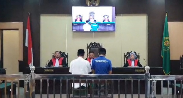 Kedua terdakwa kasus penganiayaan guru saat mengikuti sidang di PN Sampang