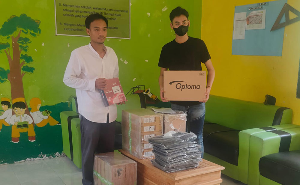 Kepala SD Islam Thoriqul Huda Zarkoni (kiri) menerima bantuan secara simbolis dari utusan dispendik.