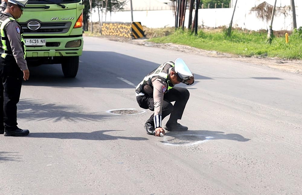 Petugas Satlantas Polres Gresik menandai jalan berlubang di Jalan Raya Daendels. Foto: Ist.