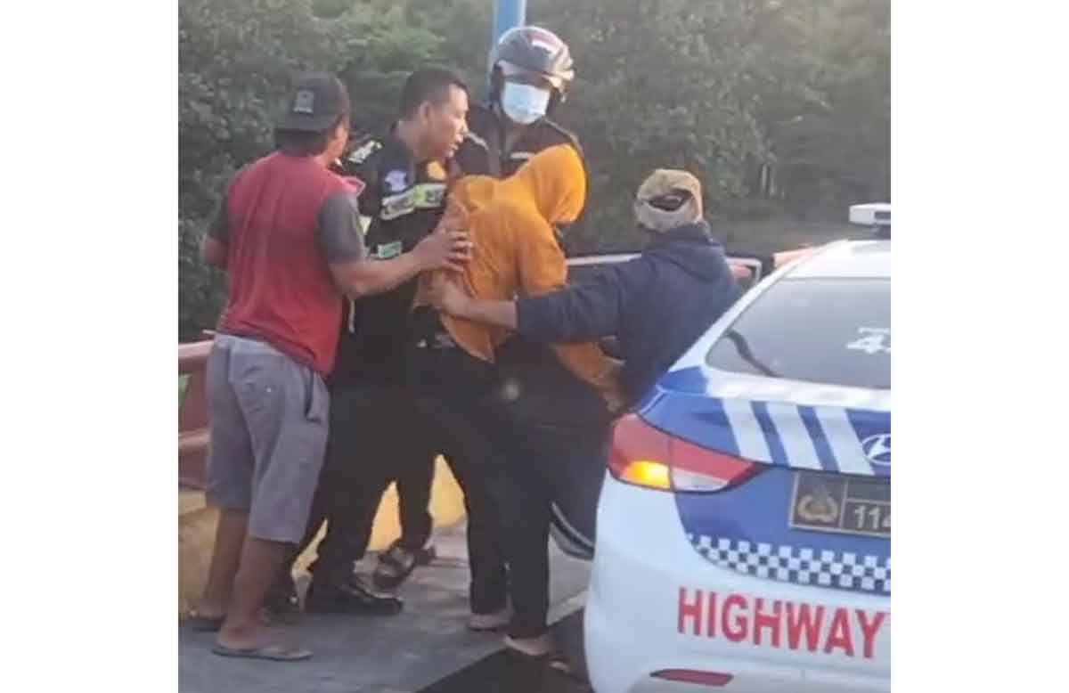 Anggota Satlantas Polres Kediri Kota saat menyelamatkan seorang lelaki yang diduga akan melakukan aksi bunuh diri di Jembatan Semampir. Foto: Ist