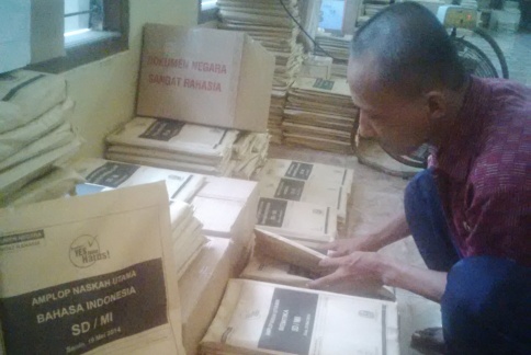 DITELITI – Petugas pengawas tengah meneliti sampul soal UN SD di Mapolres Lamongan, Kamis (15/5/2014). foto : haris sugianto/BangsaOnline