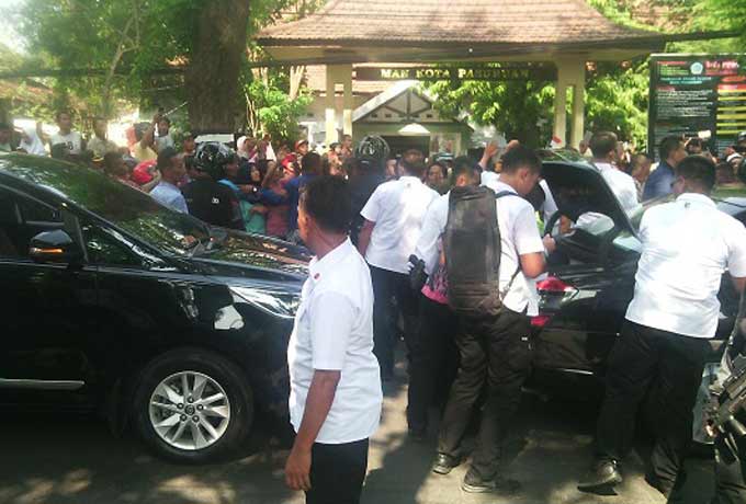 Presiden Jokowi saat turun dari mobil dinas dan membagikan buku. 