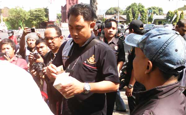 Petugas saat memeriksa uang pecahandi salah satu jasa penjual uang pecahan baru. (foto: arif kurniawan/BANGSAONLINE)
